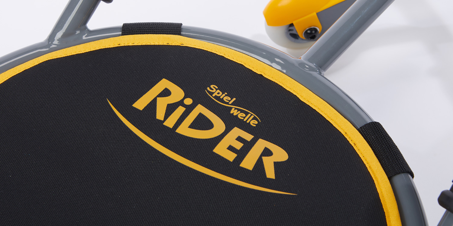 Die Textil-Sitzfläche ohne Rückenlehne ist wetterbeständig und gibt leicht nach, sodass die Kinder angenehm auf dem Rider sitzen.
